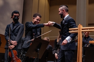 Two members of the Metropolitan Youth Symphony doing a fist bump