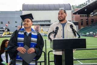 Open School graduation with student and speaker at a podium