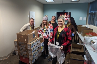 Family Justice Center volunteers unpacking large boxes of food, drinks and other supplies to distribute