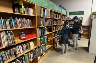Two people browsing bookshelves at Schoolhouse Supplies
