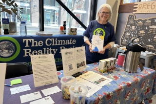 A person with The Climate Reality Project at a display table sharing information