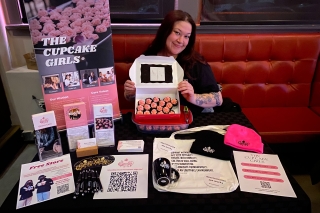 The Cupcake Girls display table of mini cupcakes, pens, knit caps, coffee mug and other marketing materials