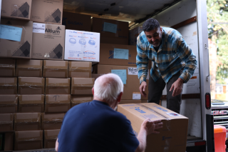 Two people loading boxes into a truck