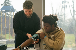 A person taking another person's blood pressure