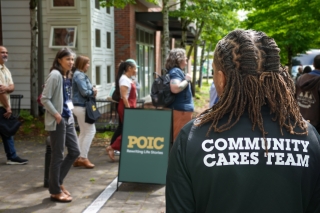 A POIC event with a person wearing a jacket that has Community Cares Team on the back