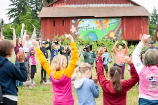 Volunteers and youth participating in a group exercise at the Zenger Farm camp
