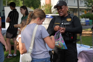 A parole officer holding a bag of colorful pens and talking with a teenager
