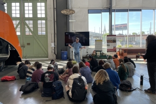 A train engineer giving a group of school children a lesson on thermal physics