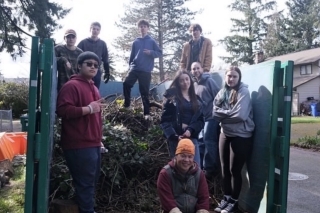 H.O.P.E volunteers standing on top of a huge pile of yard debris
