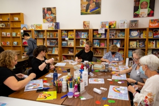 Volunteers sitting at a table and working on books at the Children's Book Bank 