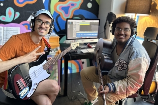 Two people in a recording session with electric guitars