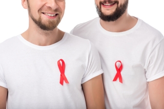 Two men wearing white t-shirts with red AIDS awareness ribbons