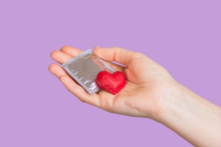 A hand holding a red heart
