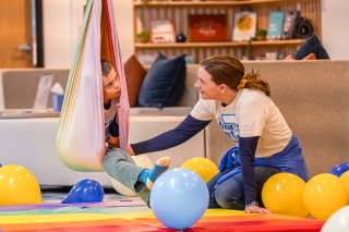 An adult playing with a child in a sensory swing