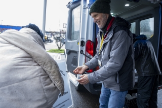 A volunteer offering help from a mobile service van