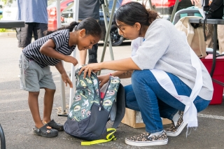 A mother and child looking into the contents of a backpack