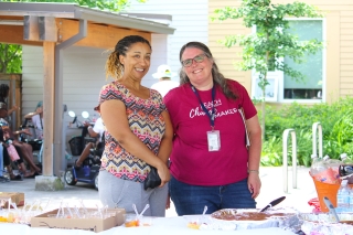 Two volunteers at an event's food and drink table