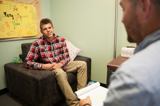 A man counseling a teenage boy