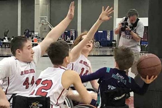 Photo of kids in wheelchairs playing basketball