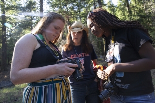 Photo of three people with cameras