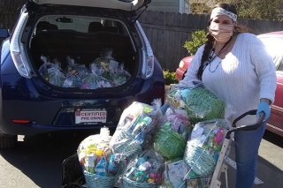 Photo of a woman loading gift baskets into a car