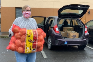 Photo of a woman with a large bag of onions