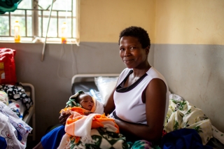 Photo of a woman in Uganda holding a baby