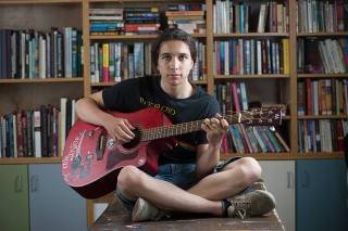 Photo of a person playing guitar