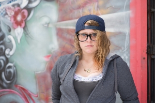 Photo of a person standing in front of a mural