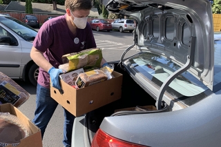 Photo of a man loading food into a car