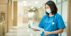 A female doctor with a mask examining a chart