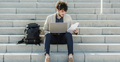 A man sitting outside on steps with his laptop