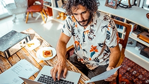 A man sitting at a desk working on his laptop