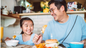 A father and daughter eating a meal together