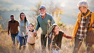 A multi-generational family holding hands in a field