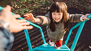 A young girl climbing up rungs