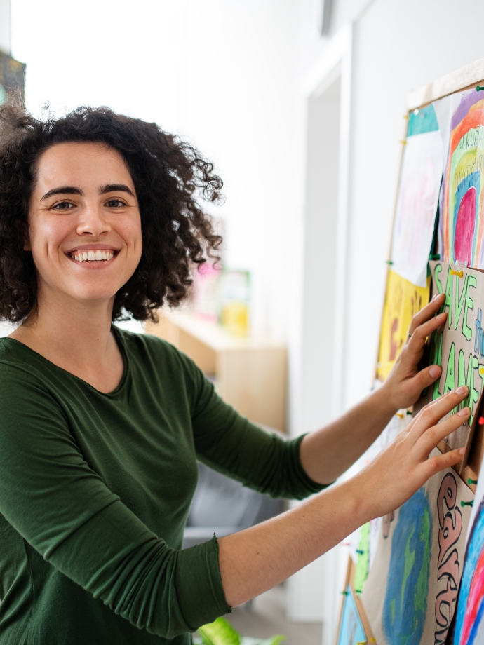 Woman hanging papers on bulletin board